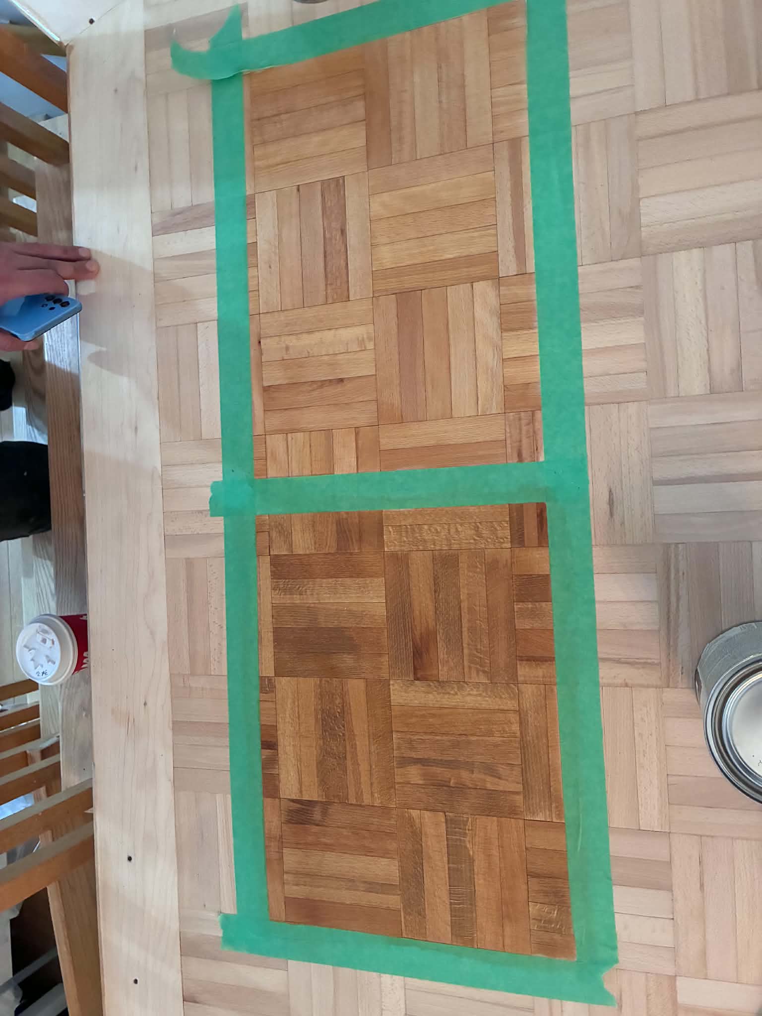 Close-up of two stain samples on a parquet floor